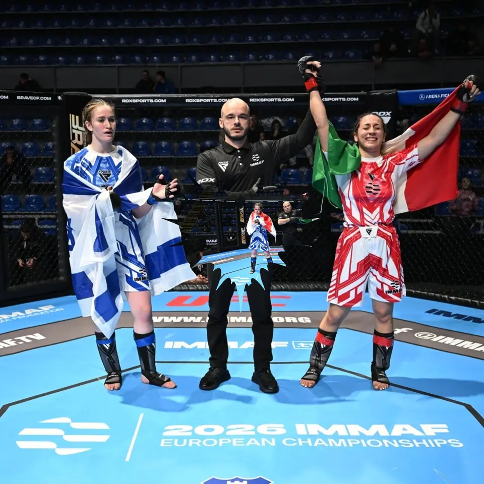 Premiazione sul ring degli europei IMMAF di MMA 2026: l’atleta Combat Academy con il tricolore a braccia alzate accanto all’arbitro